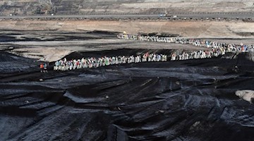 Klimaaktivisten gehen durch den Tagebau Vereinigtes Schleenhain südlich von Leipzig. Foto: Hendrik Schmidt/dpa-Zentralbild/dpa