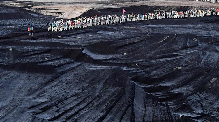 Klimaaktivisten gehen durch einen Tagebau südlich von Leipzig. Foto: Hendrik Schmidt/dpa-Zentralbild/dpa