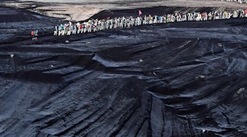 Klimaaktivisten gehen durch einen Tagebau südlich von Leipzig. Foto: Hendrik Schmidt/dpa-Zentralbild/dpa