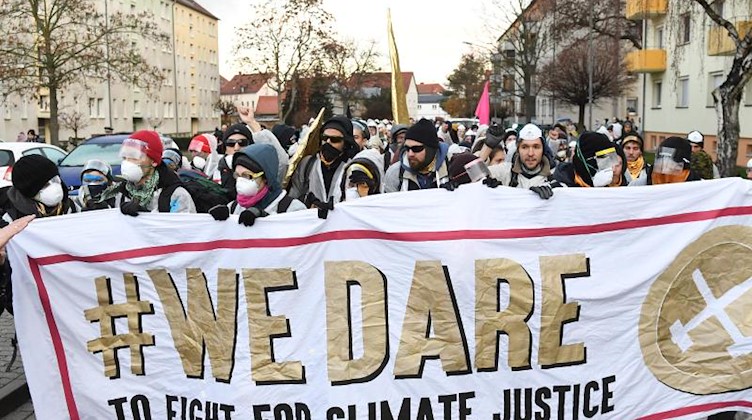 Klimaaktivisten gehen mit einem Plakat "#We dare" zum Tagebau Vereinigtes Schleenhain. Foto: Hendrik Schmidt/dpa-Zentralbild/dpa
