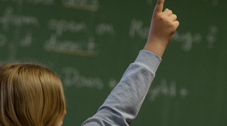 Eine Schülerin meldet sich in einem Klassenzimmer während des Englischunterrichts. Foto: Marijan Murat/dpa/Archivbild