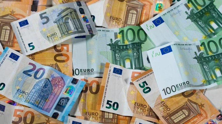 Geldscheine liegen auf einem Tisch. Foto: Jens Büttner/zb/dpa/Archivbild