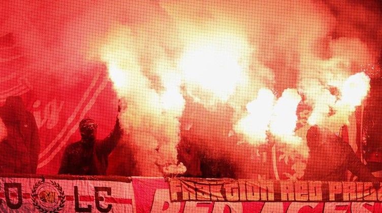 Fans aus Leipzig zünden Pyrotechnik im Gästeblock. Foto: Friso Gentsch/dpa