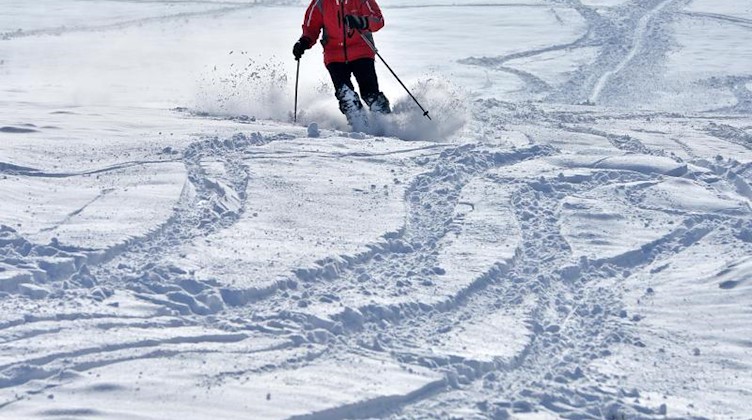 Ein Skifahrer fährt einen Hang hinunter. Foto: Martin Schutt/dpa-Zentralbild/dpa