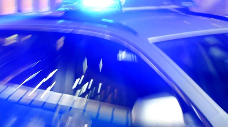 Ein Streifenwagen steht mit Blaulicht auf einer Straße. Foto: Carsten Rehder/dpa/Archivbild