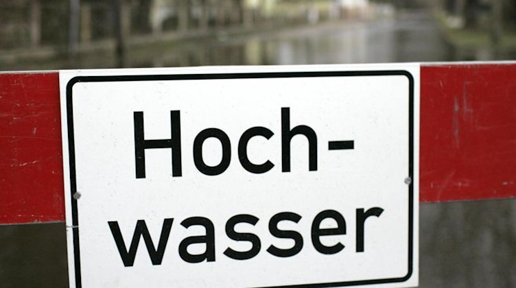 Ein Schild mit der Aufschrift «Hochwasser». Foto: Jens Wolf/dpa-Zentralbild/dpa/Archivbild