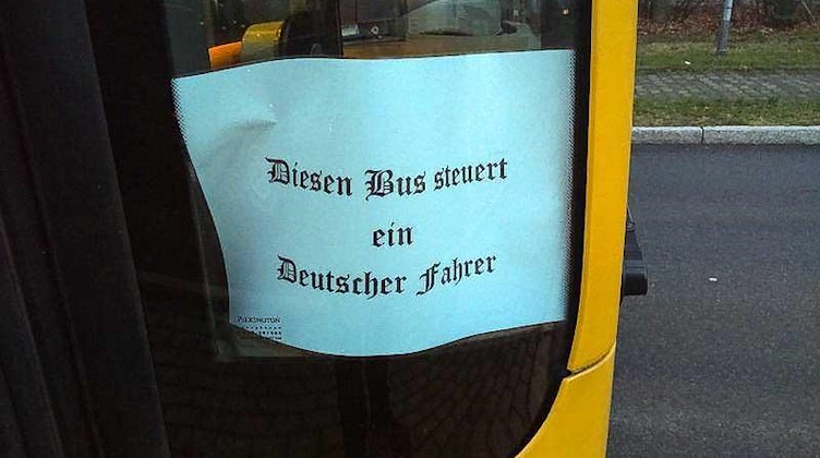 An der Seitenscheibe eines Busses steht auf einem Blatt "Diesen Bus steuert ein Deutscher Fahrer". Foto: Tino Plunert/dpa-Zentralbild/dpa/