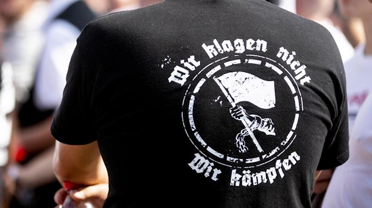 «Wir klagen nicht. Wir kämpfen» steht auf dem T-Shirt eines Teilnehmers einer Neonazi-Demonstration. Foto: ---/dpa/Archivbild