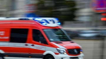 Ein Rettungsfahrzeug der Feuerwehr fährt mit Blaulicht bei einem Einsatz durch die Innenstadt. Foto: Jens Büttner/zb/dpa