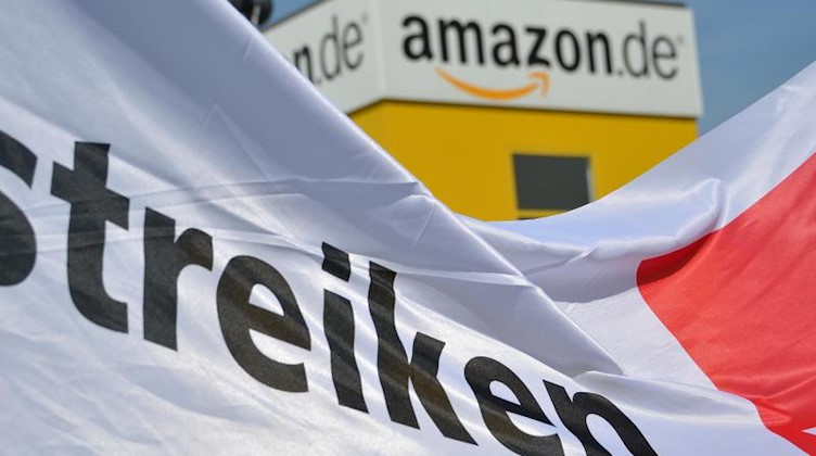 Ein Transparent mit der Aufschrift "streiken" ist vor dem Logistik-Center des Internet-Händlers Amazon aufgespannt. Foto: Uwe Zucchi/dpa