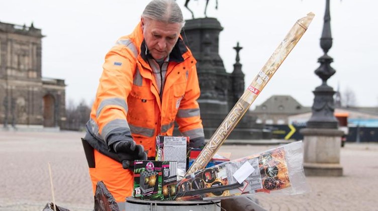 Michael Gärtner, Mitarbeiter der Stadtreinigung Dresden, sammelt Müll nach der Silvesternacht auf. Foto: Sebastian Kahnert/dpa-Zentralbild/dpa