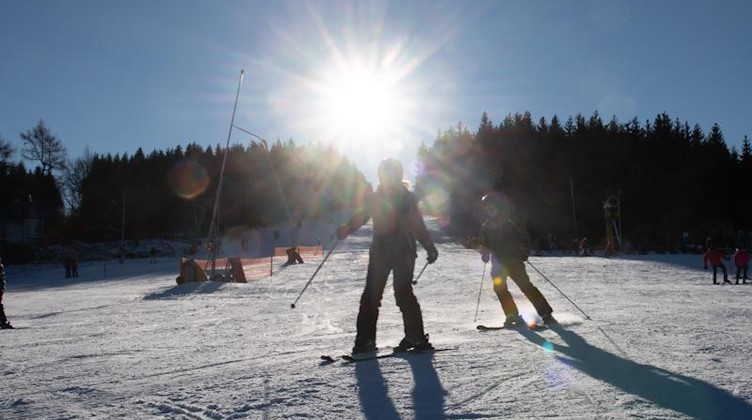 Wintersportler fahren eine Piste hinab. Foto: Sebastian Kahnert/dpa-Zentralbild/dpa/Archivbild
