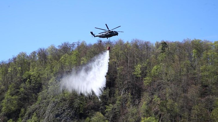Ein Hubschrauber der Bundeswehr löscht einen Brand in einem Wald. Foto: Bodo Schackow/zb/dpa/Archiv