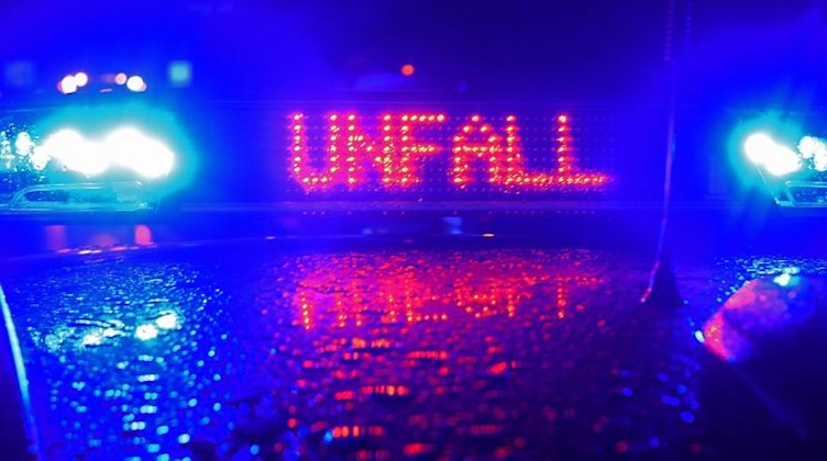 Während einer Unfallaufnahme spiegeln sich das Blaulicht und der Schriftzug "Unfall" auf dem Dach eines Polizeiwagens. Foto: Stefan Puchner/dpa/Archiv