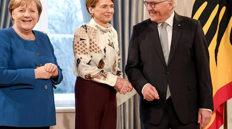 Bundeskanzlerin Angela Merkel (CDU, l) mit Bundespräsident Frank-Walter Steinmeier (SPD) und seiner Frau Elke Büdenbender. Foto: Britta Pedersen/dpa-Zentralbild/dpa