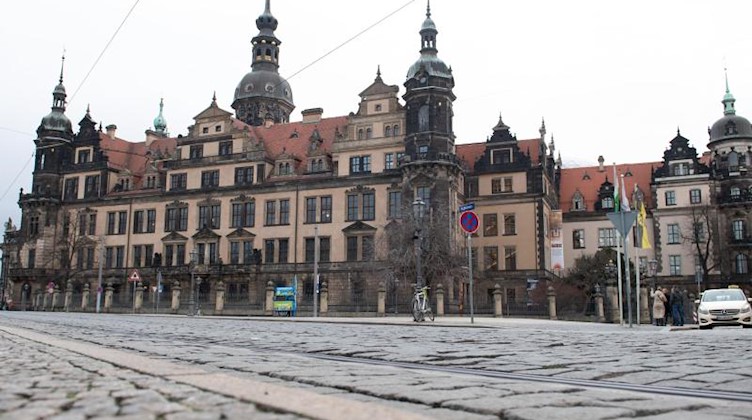 Passanten stehen vor dem Residenzschloss mit dem Grünen Gewölbe. Foto: Sebastian Kahnert/dpa-Zentralbild/dpa/Archivbild