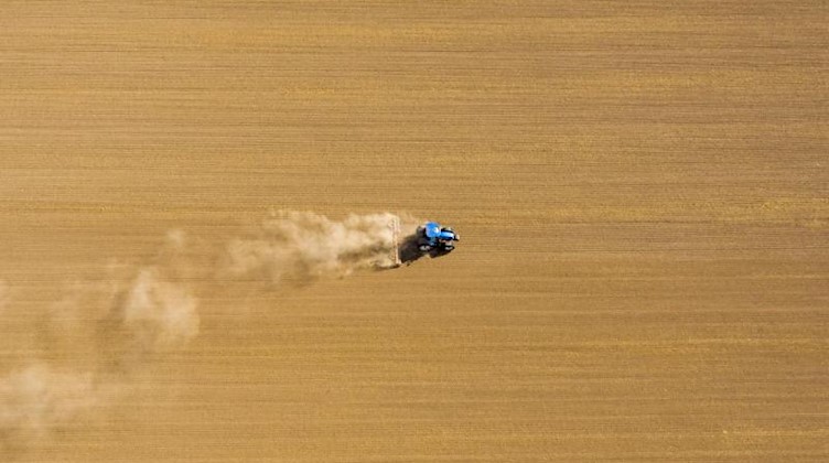 Ein Traktor auf einem Feld. Foto: Jan Woitas/zb/dpa/Archivbild