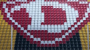 Das Dynamo-Logo auf Zuschauersitzen im Stadion des Fußball-Drittligisten. Foto: Arno Burgi/dpa-Zentralbild/dpa/Archivbild
