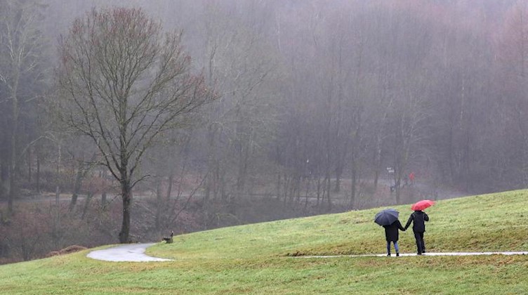 Spaziergänger sind an einem nebeligen Tag unterwegs. Foto: Rene Traut/dpa/Archivbild