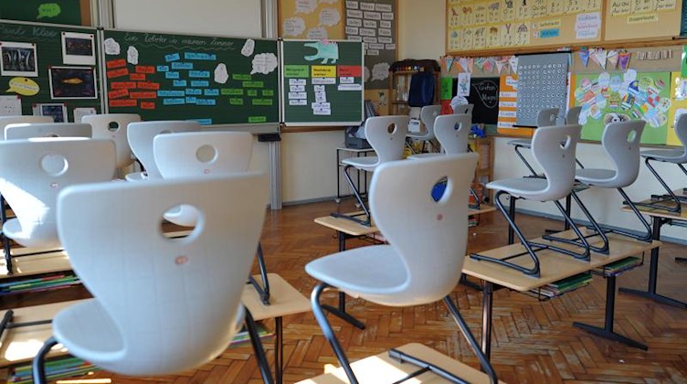 Stühle stehen in einer Grundschule auf den Tischen. Foto: David Ebener/dpa/Archivbild