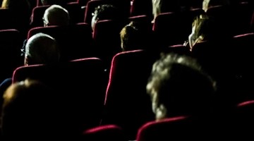 Besucher eines FernsehKrimi-Festivals sitzen in einem Kino. Foto: Nicolas Armer/dpa/Archivbild
