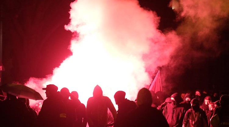Teilnehmer einer linken Demonstration zünden Pyrotechnik. Foto: Sebastian Willnow/dpa-Zentralbild/dpa