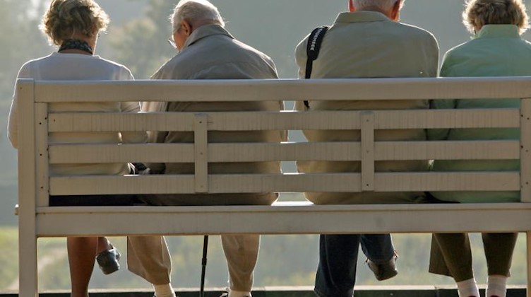 Rentner sitzen auf einer Parkbank. Foto: Ralf Hirschberger/zb/Archiv