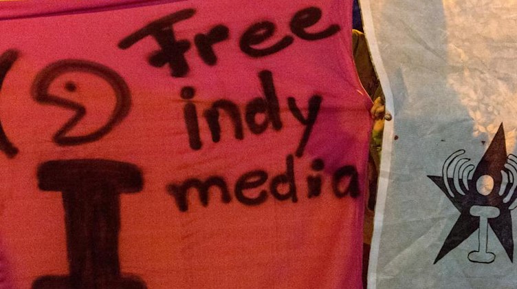 Anhänger der linken Szene halten bei einer Demonstration ein Banner mit der Aufschrift «Free Indymedia». Foto: Patrick Seeger/dpa/Archivbild