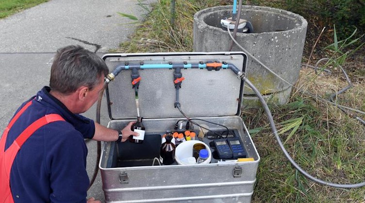 Ein Mitarbeiter nimmt an einer Messstelle eine Grundwasserprobe, die in einem Labor auf Nitrat überprüft wird. Foto: Uli Deck/dpa/Archivbild