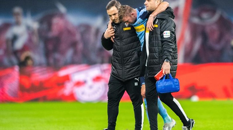 Mönchengladbachs Christoph Kramer wird verletzt vom Feld geführt. Foto: Robert Michael/dpa-Zentralbild/dpa