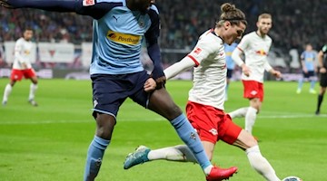 Gladbachs Marcus Thuram (l) und Leipzigs Marcel Sabitzer während des Spiels im Duell. Foto: Jan Woitas/dpa-Zentralbild/dpa