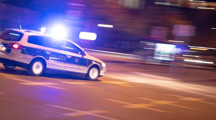 Ein Polizeiauto fährt unter Einsatz von Blaulicht und Sirene eine Straße entlang. Foto: Lino Mirgeler/dpa/Symbolbild