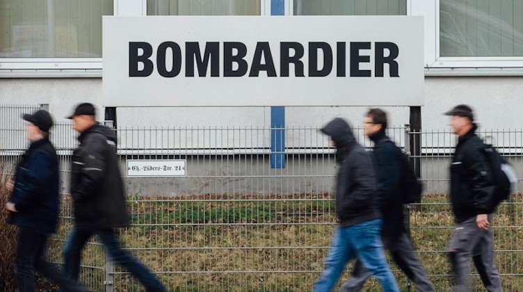 Mitarbeiter gehen am Werk von Bombardier vorbei. Foto: Oliver Killig/dpa-Zentralbild/dpa/Archivbild