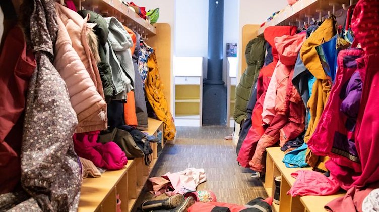 Blick über die Garderobe mit Jacken, Mützen und anderen Kleidungsstücken in einem Kindergarten. Foto: Christian Charisius/dpa/Archiv