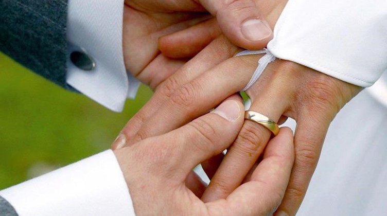 Bei der Trauung streift der Bräutigam der Braut einen Ehering über den Ringfinger. Foto: Andreas Lander/dpa-Zentralbild/dpa/Archivbild