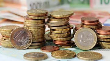 Euro-Münzen auf Euro-Banknoten. Foto: Tobias Hase/dpa/Symbolbild