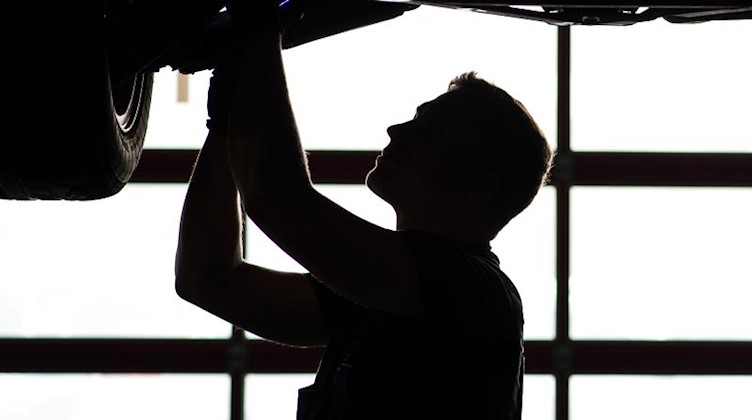 Ein Mechaniker arbeitet in einer KfZ-Werkstatt. Foto: David Ebener/dpa/Archivbild