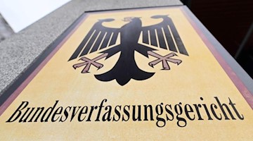 Ein Hinweisschild mit dem Schriftzug «Bundesverfassungsgericht» steht vor dem Gericht. Foto: Uli Deck/dpa/Archivbild
