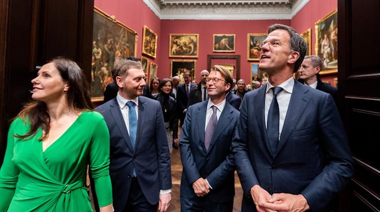 Michael Kretschmer (CDU, 2.v.l.), seine Lebensgefährtin Annett Hofmann (l), Mark Rutte (r) und Taco Dibbits (2.v.r.) laufen durch die wiedereröffnete Gemäldegalerie «Alte Meister». Foto: Robert Michael/dpa-Zentralbild/dpa/Archiv