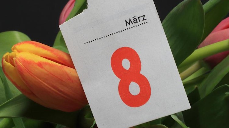 Das Kalenderblatt vom 8. März, dem Internationalen Frauentag, liegt auf einem Strauß Tulpen. Foto: Jens Wolf/zb/dpa/Archivbild