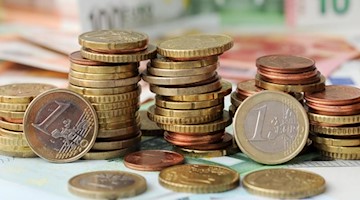 Euro-Münzen auf Euro-Banknoten. Foto: Tobias Hase/dpa/Symbolbild