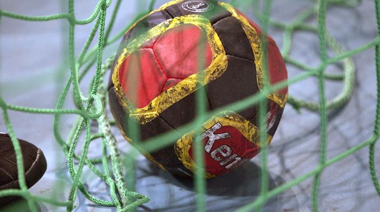 Ein Handball liegt im Netz. Foto: Rainer Jensen/dpa/Archivbild