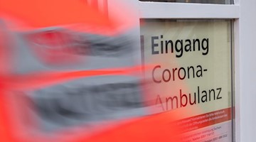 Ein Notarzt geht durch den Eingang der Corona-Ambulanz. Foto: Robert Michael/dpa
