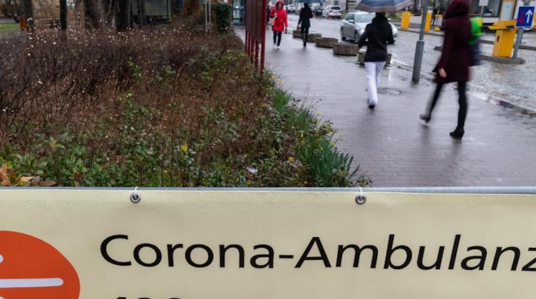 Ein Hinweisschild mit der Aufschrift «Corona-Ambulanz» hängt am Eingang am Dresdner Uniklinikum. Foto: Robert Michael/dpa/Archiv