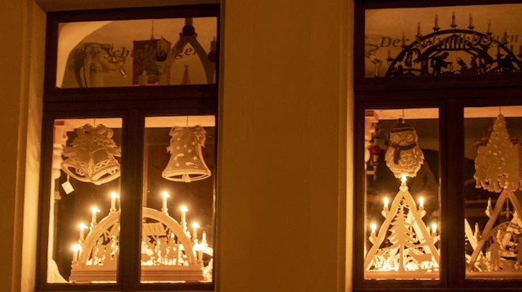 Zwei Schwibbögen leuchten in einem Haus auf der Fensterbank. Foto: Bernd März/dpa-zentralbild/dpa
