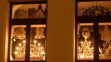 Zwei Schwibbögen leuchten in einem Haus auf der Fensterbank. Foto: Bernd März/dpa-zentralbild/dpa