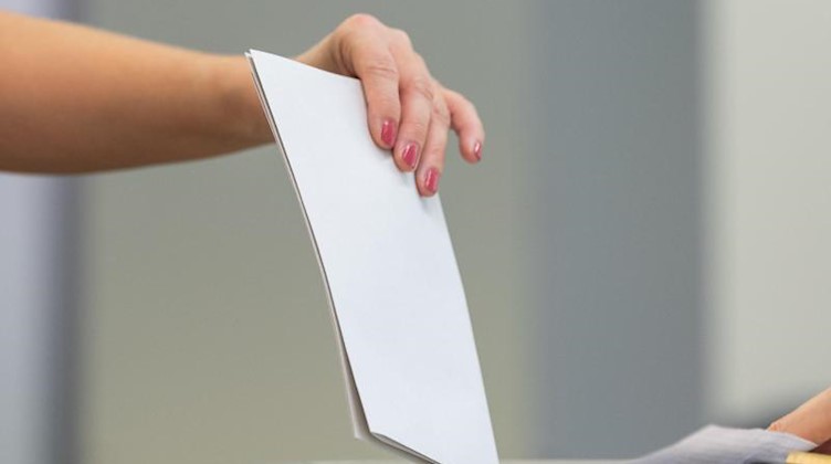 Eine Wählerin wirft einen Wahlzettel in einem Wahllokal in eine Wahlurne. Foto: Robert Michael/dpa-Zentralbild/dpa/Symbolbild