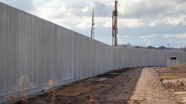 Eine sechs Meter hohe Betonmauer umschließt das Gelände für das künftige Zwei-Länder-Gefängnis in Zwickau-Marienthal. Foto: Jan Woitas/dpa-Zentralbild/dpa/Archivbild