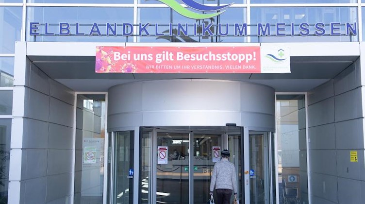Ein Banner mit der Aufschrift «Bei uns gilt Besuchsstopp» hängt über dem Eingang des Elblandklinikum Meißen. Foto: Sebastian Kahnert/dpa-Zentralbild/dpa/Archivbild