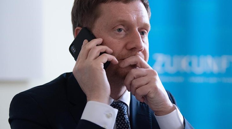Michael Kretschmer (CDU), Ministerpräsident von Sachsen, telefoniert. Foto: Sebastian Kahnert/dpa-Zentralbild/dpa/Archivbild